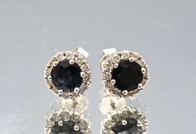 Lot 23 - A pair of 18ct gold sapphire and diamond cluster stud earrings