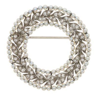 Lot 16 - An Edwardian white metal diamond and pearl wreath brooch