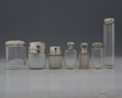 Lot 88 - A group of silver-topped glass bottles, to...