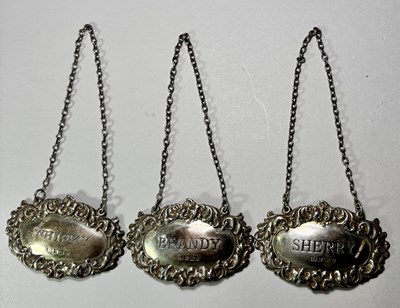 Lot 674 - Three 1970's silver decanter labels
