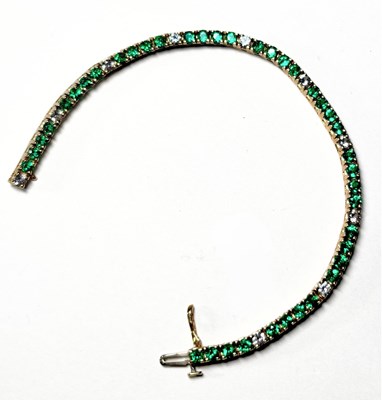 Lot 666 - A 14ct gold synthetic emerald and white sapphire line bracelet