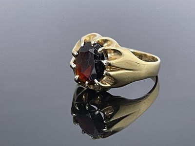 Lot 160 - A 9 carat gold and garnet ring, claw set oval...