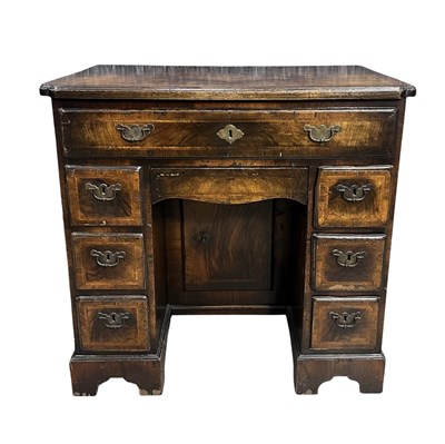 Lot 881 - A George I walnut kneehole desk, the top with...