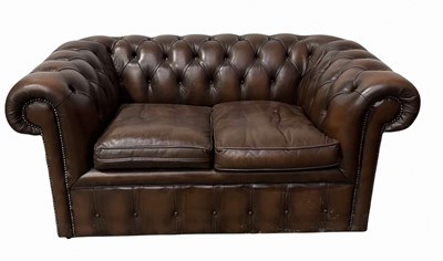Lot 985 - A two seater brown leather, button back,...