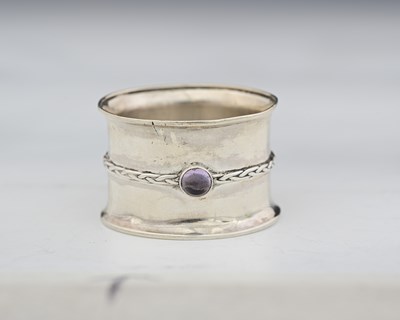 Lot 55 - An Arts and Crafts silver and gem set napkin...