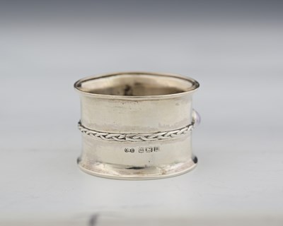 Lot 55 - An Arts and Crafts silver and gem set napkin...