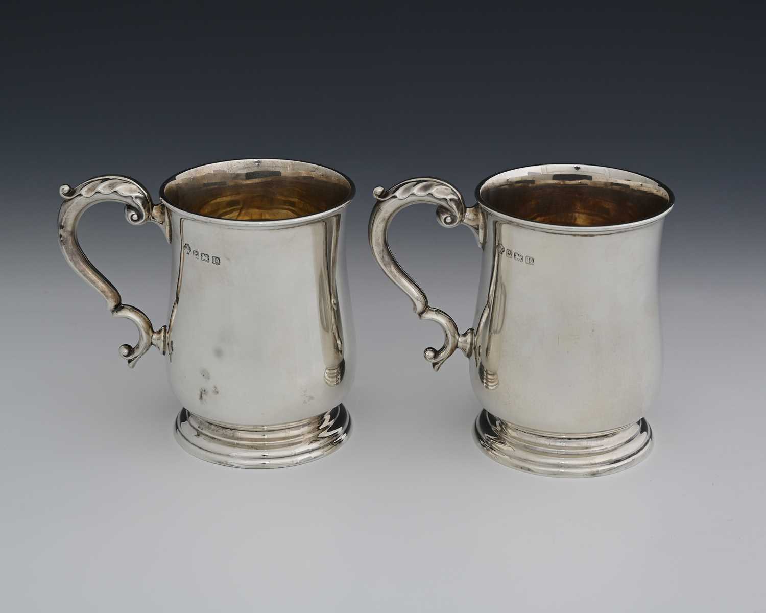 Lot 87 - A pair of George V silver pint mugs, by...