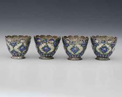 Lot 150 - A set of four silver-coloured metal and enamel...