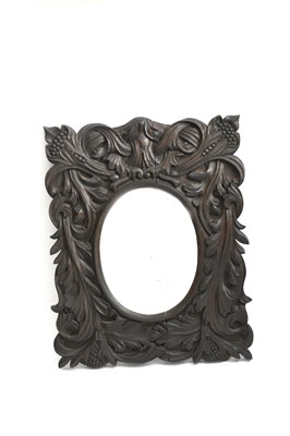 Lot 444 - A carved oak wall mirror, rectangular, carved...
