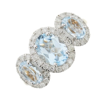 Lot 125 - A 9ct gold three stone oval-shape topaz and brilliant-cut diamond cluster ring