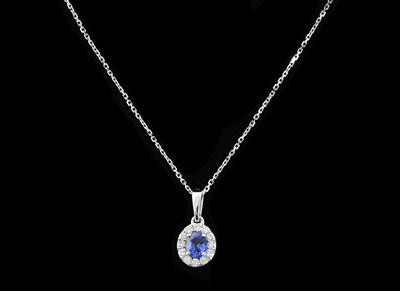 Lot 455 - A 9ct gold oval-shape sapphire and brilliant-cut diamond cluster pendant