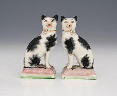 Lot 650 - A pair of black and white pottery chimney cat...