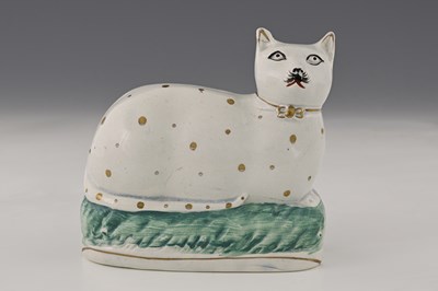 Lot 663 - A Staffordshire figure of a recumbent cat,...