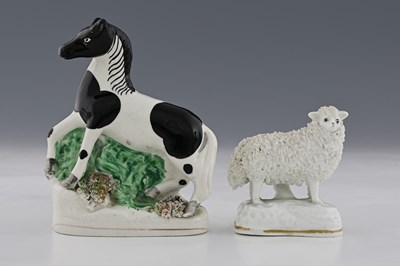 Lot 667 - Two Staffordshire figures, modelled as a black...
