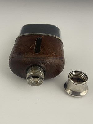 Lot 24 - A Victorian hip flask, the glass body mounted...