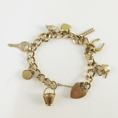 Lot 152 - A 9ct yellow gold charm bracelet, the oval...