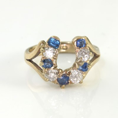 Lot 182 - A 9ct gold horseshoe ring, nine diamonds and...