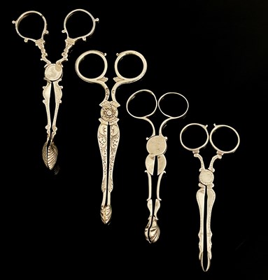 Lot 409 - A group of four silver tea tongs, each of...