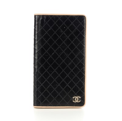 Lot 267 - Chanel, a bifold wallet, crafted from black...